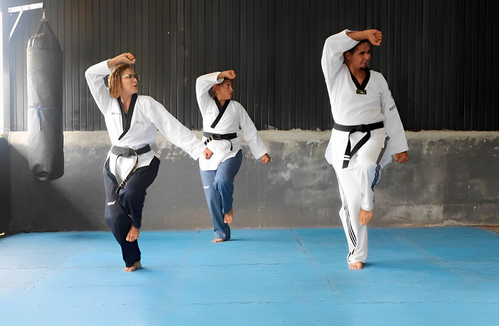 Enquanto sonha viver do taekwondo, casal de refugiados dá aulas em projeto social no DF
